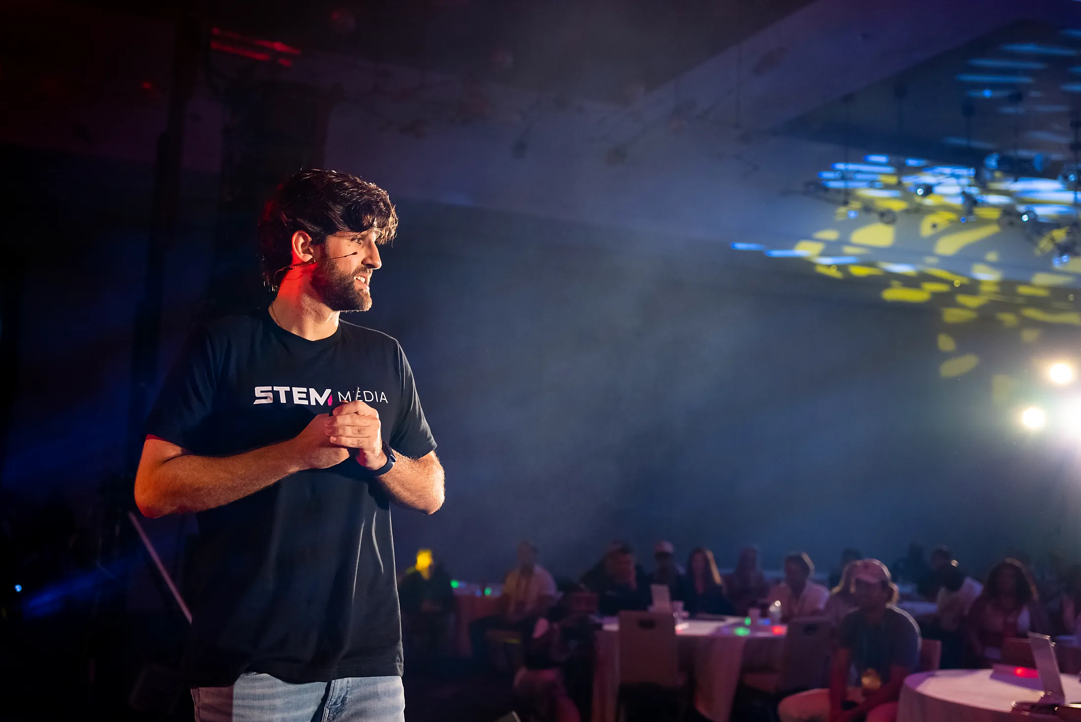 A speaker on the CreatorHub main stage under the lights